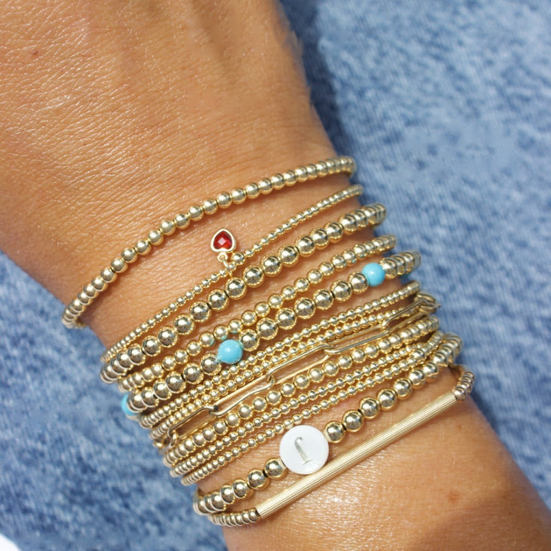 Stack of JAM Jewels 14k gold-filled bracelets on the wrist
